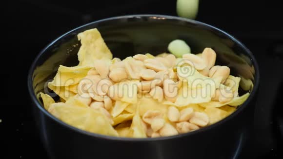 盘啤酒小吃特写在碗里加入盐坚果落在盘子里螺母的慢动作视频视频的预览图