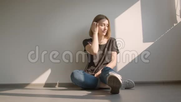 一幅年轻漂亮的白种人女性的特写肖像她坐在窗边在室内愉快地微笑着视频的预览图