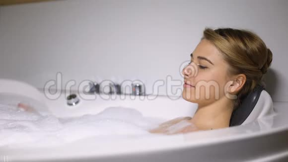放松的女性享受泡泡按摩浴spa和健康视频的预览图