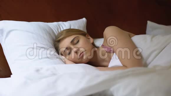 美丽的女性睡在舒适舒适的床垫上睡眠时间安排视频的预览图