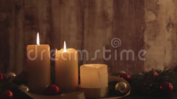 圣诞节的背景是点燃的蜡烛带着移动的火焰松枝天然松果红色和金色的缎带装饰视频的预览图