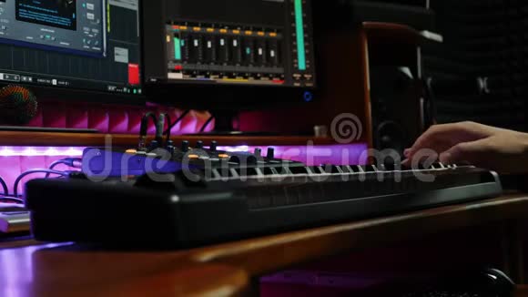 专业音乐家在录音室用电钢琴演奏MIDI键盘男性手弹钢琴家庭音乐种马视频的预览图