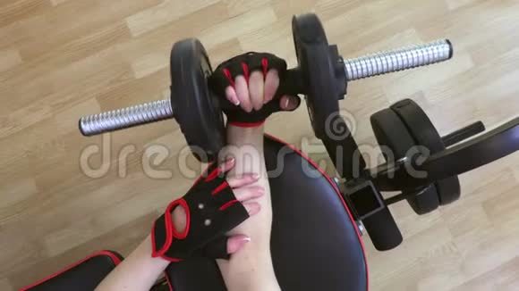 健身房里用哑铃做前臂健身运动的女人视频的预览图