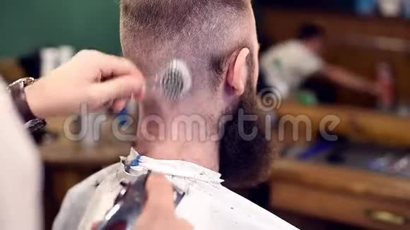 用剪刀剪头发用刷子从头后抖掉头发在理发店剪短头发视频的预览图