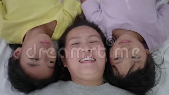 亚洲母亲和她的女儿在床上拥抱视频的预览图