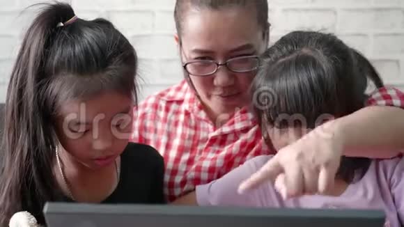 年轻的母亲和她的女儿正在卧室里玩笔记本电脑视频的预览图