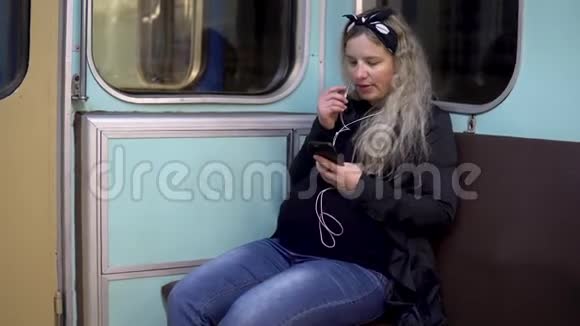 一位孕妇正在通过耳机和地铁列车通话旧地铁列车视频的预览图