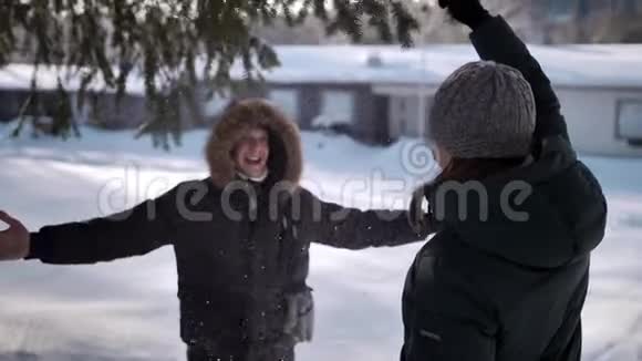 一个年轻的女人摇着一根松枝男人下雪男人拥抱女人视频的预览图