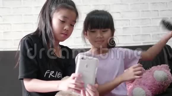 孩子们小女孩在家玩智能手机视频的预览图