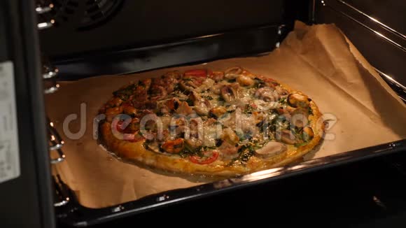 女厨师从烤箱里烤披萨在家做披萨厨房女性准备的披萨视频的预览图
