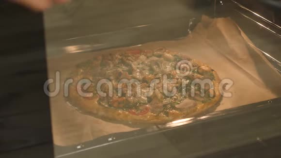 厨师打开烤箱门检查披萨准备情况烤披萨靠近侧景从烤箱里拿披萨的女人视频的预览图