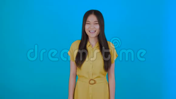 兴奋的年轻女士站在蓝色背景上女孩赞许地点头视频的预览图