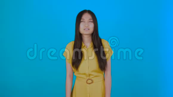 兴奋的年轻女士站在蓝色背景上孤立的形象讽刺的女孩点头4K视频的预览图