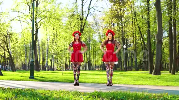 两位身着鲜艳服装的女舞者在阳光公园表演民族舞视频的预览图