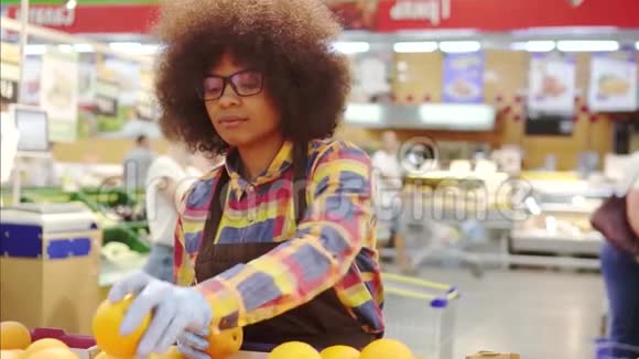 超级市场雇员非洲裔美国妇女有非洲发型整理水果慢莫视频的预览图