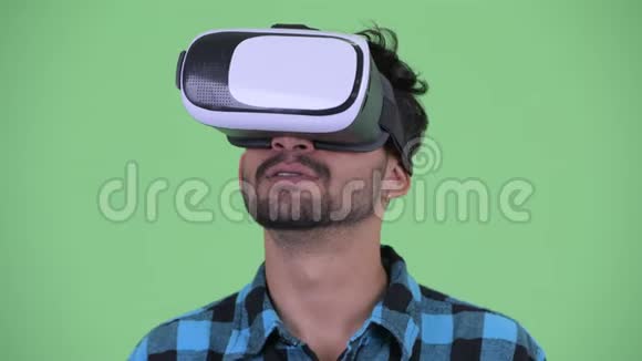 使用虚拟现实耳机的快乐年轻留胡子的波斯时髦男人的脸视频的预览图