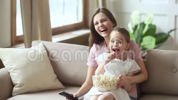 妈妈和小女儿在看喜剧时笑着吃爆米花视频的预览图