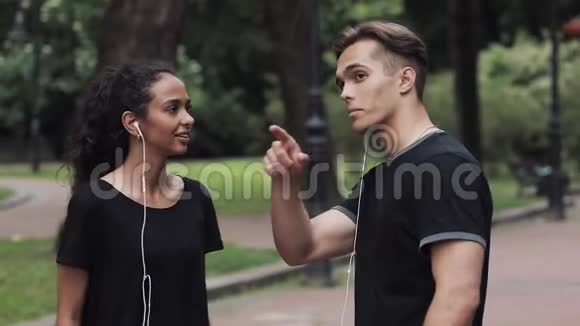 年轻英俊的男人给公园里的音乐女孩指路视频的预览图