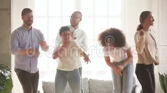 活跃的各种快乐的朋友在客厅跳舞视频的预览图