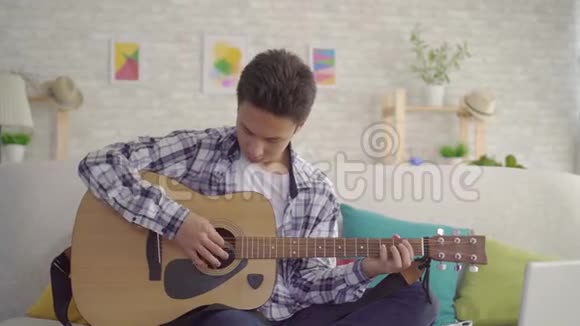 亚洲青年音乐家弹吉他的肖像视频的预览图