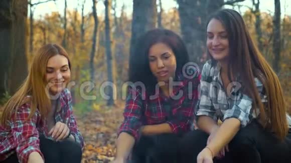 快乐的女孩在露营时用篝火烤棉花糖视频的预览图