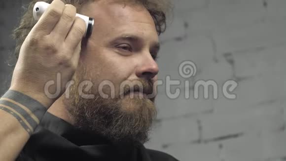 有胡子的人用电动修边器剃头胡须朋克嬉皮士剃了他的莫霍克4k录像慢动作2398视频的预览图