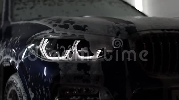 大灯在洗车的车里打开SUV在泡沫中视频的预览图