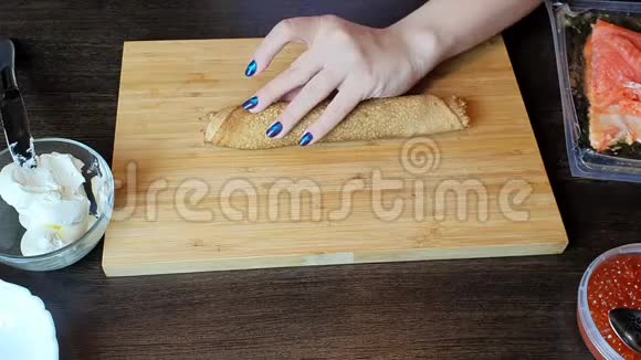 厨房里的一个女孩用刀子把煎饼切成卷视频的预览图