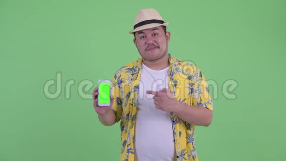 快乐的年轻超重亚洲游客带着电话竖起大拇指视频的预览图