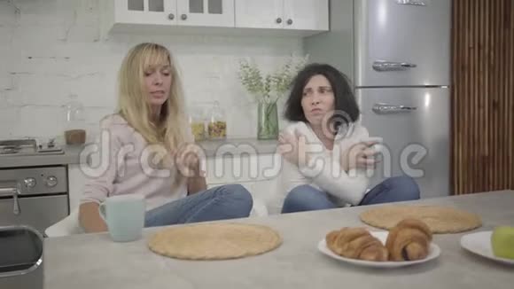 两个白人成年妇女早上坐在桌前喝咖啡的肖像精疲力竭的女性肖像视频的预览图