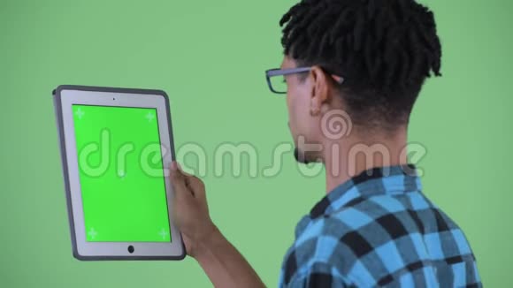 使用数码平板电脑近距离观看年轻快乐的非洲嬉皮士视频的预览图