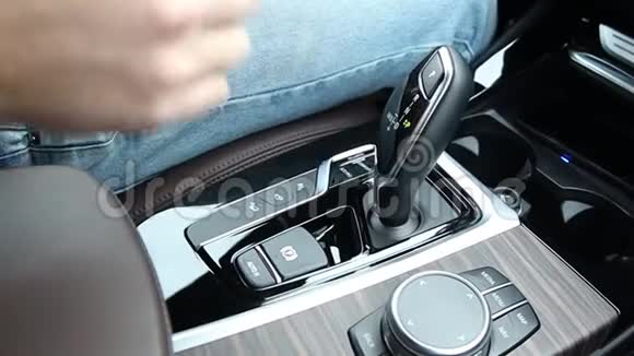 一个人在汽车自动变速箱上切换驾驶模式视频的预览图