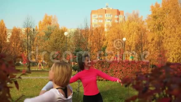 在秋天公园跳舞的爱笑的女人视频的预览图