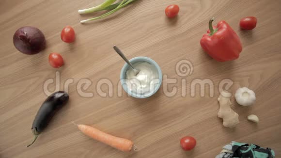 女人手从木桌上的蓝碗里拿一勺希腊酸奶视频的预览图