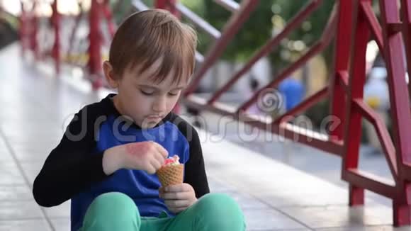 可爱的男孩在户外吃冰淇淋快乐的孩子散步快乐的童年视频的预览图