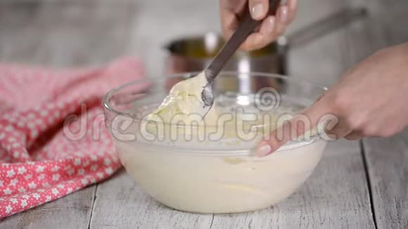 在做蛋糕的过程中混合雌性手把热牛奶倒入蛋糕面糊中视频的预览图