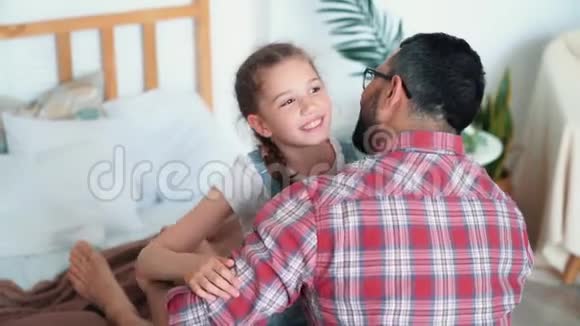 爸爸拥抱并亲吻他的女儿女孩用手表现出心跳动作缓慢视频的预览图