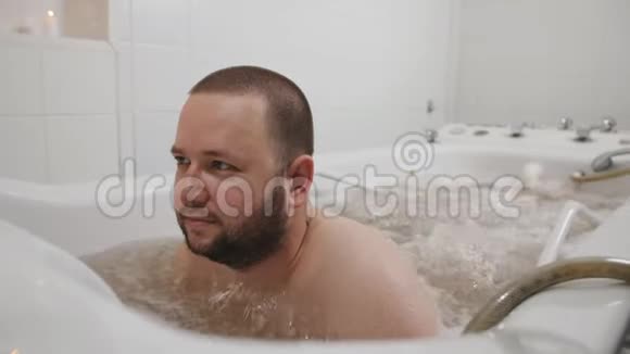 放松休闲的男人躺在温泉沙龙的热水浴缸里视频的预览图