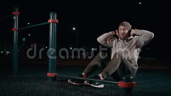 男运动员夜间在公园锻炼上身肌肉抬起躯干视频的预览图