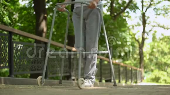 病人的腿在医院公园里借助步行架慢慢移动视频的预览图