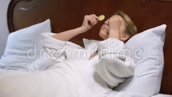 女人躺在床上把黄瓜放在眼睛上自然的美容程序更新视频的预览图