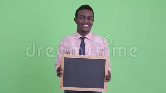 快乐的年轻非洲商人拿着黑板说话视频的预览图