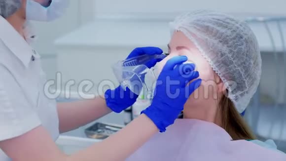 牙医在牙科治疗牙齿前给病人戴上防护眼镜视频的预览图