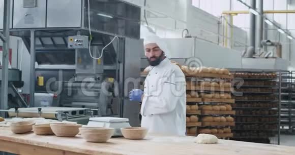 面包师留着胡子的面包师在面包店的厨房里跳舞一边准备烤面包食品厂视频的预览图
