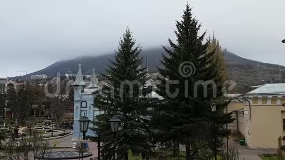 在一个多云的秋日在Pyatigorsk马舒克山的景色勒蒙托夫画廊的屋顶和公园里的松树视频的预览图