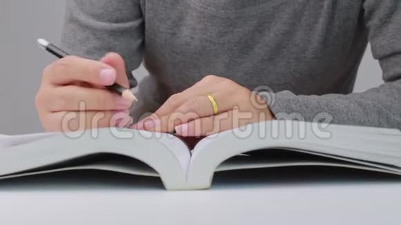 在图书馆阅读一本书时把女人的手画一条线写一篇简短的摘要视频的预览图