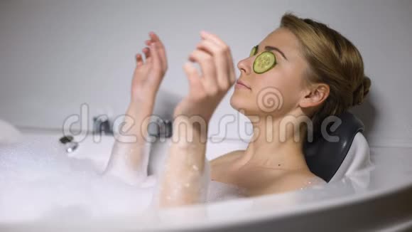 女人在洗澡的时候眼睛上有泡沫泡泡和黄瓜对着镜头眨眨眼视频的预览图
