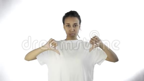 穿着白色t恤的漂亮少女拇指朝下双手放在白色背景上视频的预览图