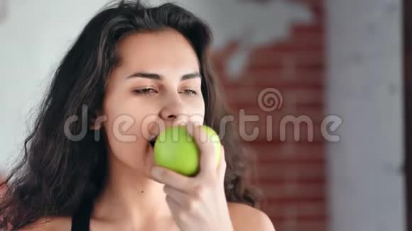 一张饥饿美丽的年轻女孩的特写脸她有着完美的皮肤吃着苹果看着相机视频的预览图