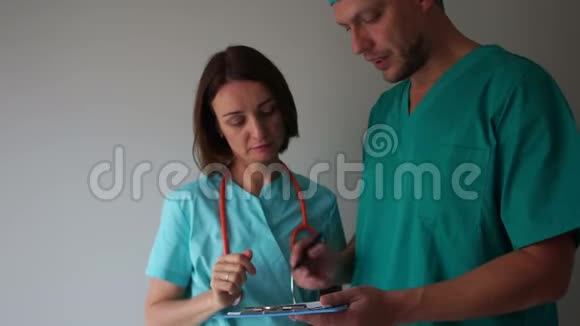 女医生和穿绿色医疗礼服的男医生讨论操作问题医疗和保健视频的预览图